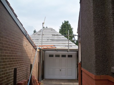 New roof on garage. View from neighbours drive. Existing asbestos tiles were safely removed under licence and disposed off as per current guidelines. Roof has been felted and battened ready for tiles.